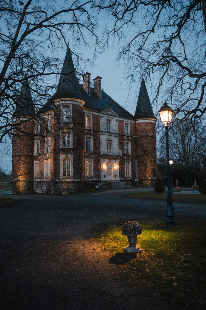 A beautiful medieval castle in Le Rheu, Bretagne, France at twilight, illuminated softly.